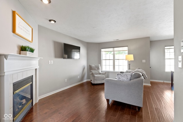 603 Daviess Dr, Westfield, IN 46074 - living room featuring baseboards, a tile fireplace, dark wood-style flooring, and a textured ceiling
