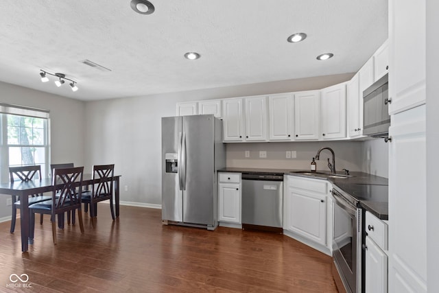 603 Daviess Dr, Westfield, IN 46074 - kitchen with appliances with stainless steel finishes, a sink, dark countertops, white cabinets, and a textured ceiling