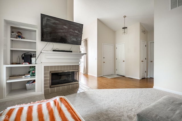 8223 Thoroughbred Run, Indianapolis, IN 46256 - unfurnished living room with a fireplace, baseboards, built in shelves, wood finished floors, and lofted ceiling