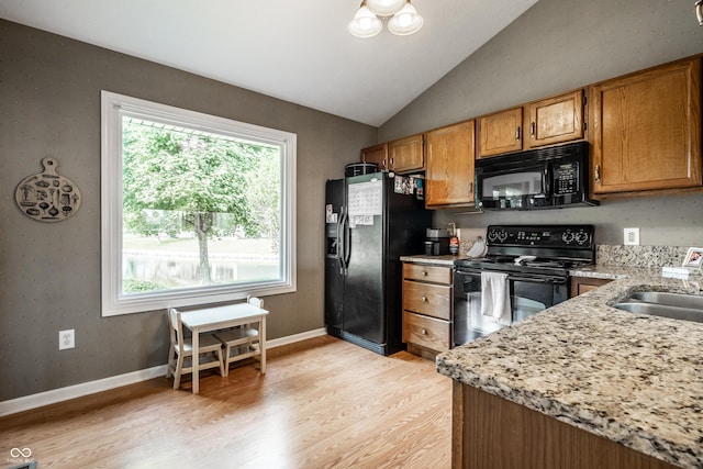 8223 Thoroughbred Run, Indianapolis, IN 46256 - kitchen with black appliances, light wood finished floors, a sink, lofted ceiling, and brown cabinetry