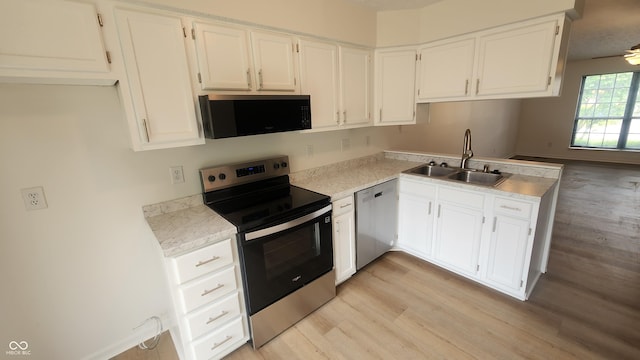 1836 Queensbridge Cir, Indianapolis, IN 46219 - kitchen with stainless steel appliances, a sink, light wood-style floors, and white cabinets
