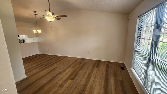 1836 Queensbridge Cir, Indianapolis, IN 46219 - unfurnished living room with a ceiling fan, vaulted ceiling, dark wood-style flooring, a chandelier, and baseboards