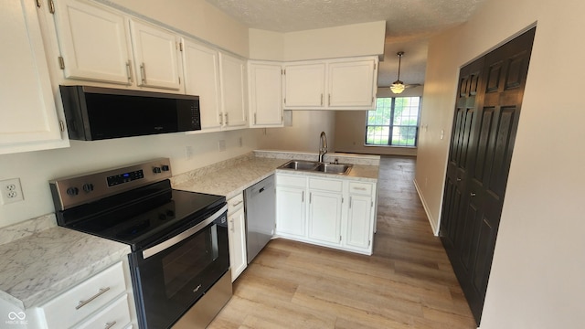 1836 Queensbridge Cir, Indianapolis, IN 46219 - kitchen with appliances with stainless steel finishes, a sink, light wood finished floors, white cabinetry, and light countertops