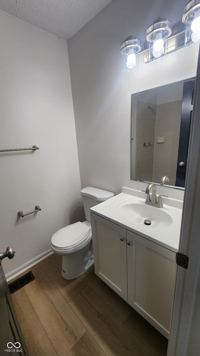 1836 Queensbridge Cir, Indianapolis, IN 46219 - bathroom with toilet, vanity, wood finished floors, a textured ceiling, and a shower