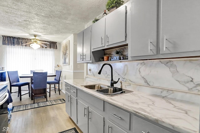 2832 Hillside Ave, Indianapolis, IN 46218 - kitchen featuring a sink, a textured ceiling, a ceiling fan, light wood-style floors, and open shelves