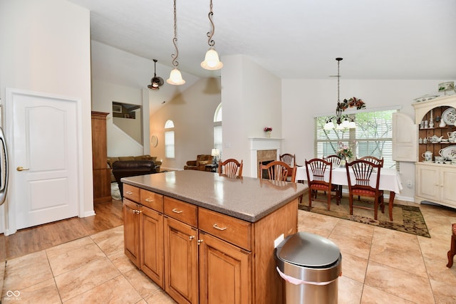2805 Rylee Ct, Greenwood, IN 46143 - kitchen with vaulted ceiling, a kitchen island, pendant lighting, light tile patterned floors, and brown cabinets