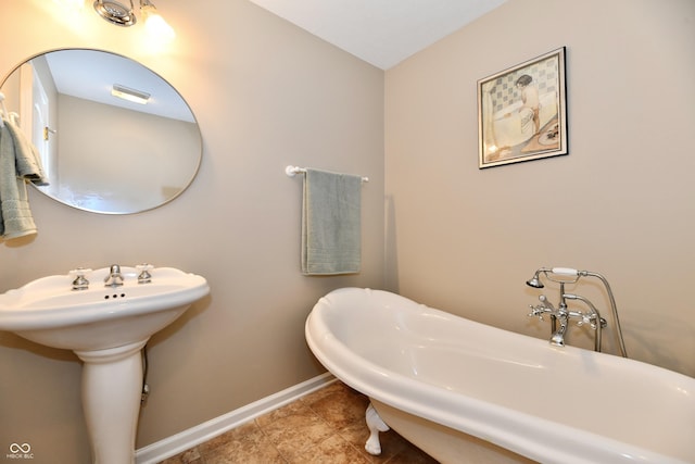 2805 Rylee Ct, Greenwood, IN 46143 - full bathroom featuring baseboards, a freestanding bath, and a sink
