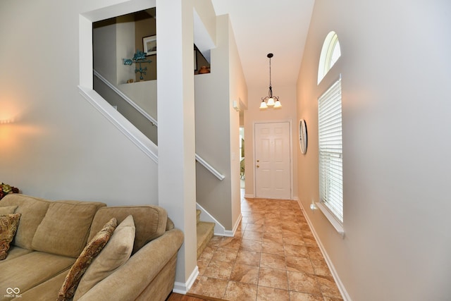 2805 Rylee Ct, Greenwood, IN 46143 - entryway featuring stairway, light stone finish floors, a chandelier, a high ceiling, and baseboards