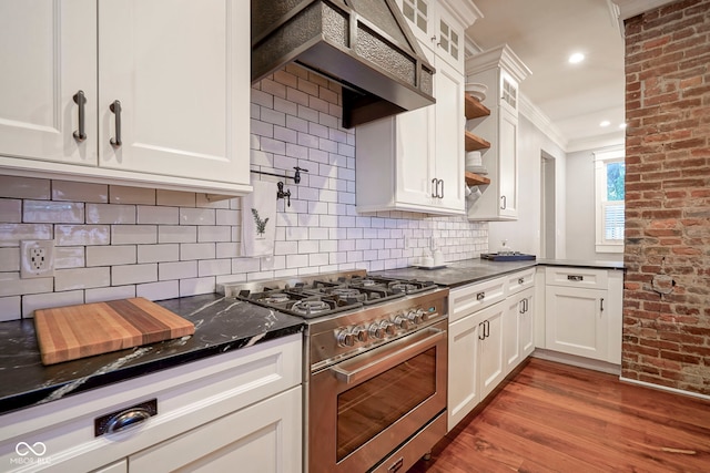 1512 Bellefontaine St, Indianapolis, IN 46202 - kitchen featuring high end stainless steel range, wall chimney range hood, white cabinetry, wood finished floors, and decorative backsplash