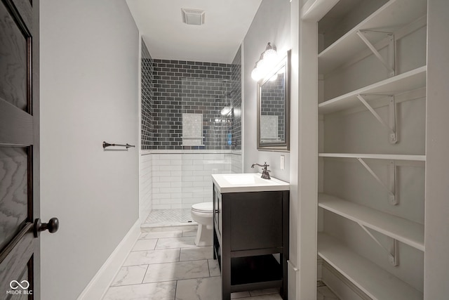 1512 Bellefontaine St, Indianapolis, IN 46202 - full bathroom with marble look tile flooring, vanity, toilet, a tile shower, and baseboards