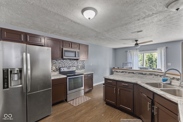 9125 Timpani Way, Indianapolis, IN 46231 - kitchen featuring stainless steel appliances, dark wood-type flooring, tasteful backsplash, light countertops, and a textured ceiling