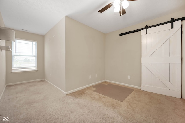 1412 Huntzinger Blvd, Pendleton, IN 46064 - unfurnished bedroom with a barn door, carpet flooring, baseboards, and ceiling fan