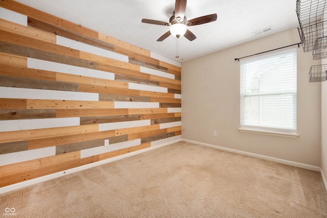1412 Huntzinger Blvd, Pendleton, IN 46064 - spare room with wood walls, ceiling fan, light colored carpet, and baseboards