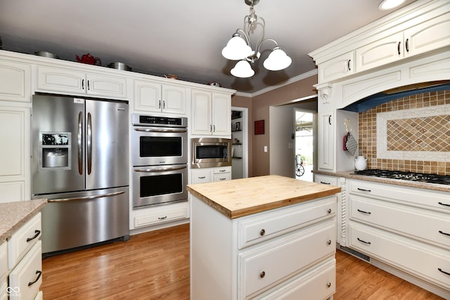 1910 Ivy Dr, Anderson, IN 46011 - kitchen featuring appliances with stainless steel finishes, wood counters, a chandelier, decorative backsplash, and a kitchen island