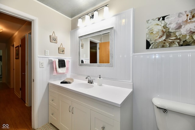 1910 Ivy Dr, Anderson, IN 46011 - half bathroom with vanity, toilet, wainscoting, and wood finished floors