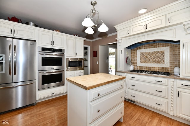 1910 Ivy Dr, Anderson, IN 46011 - kitchen with appliances with stainless steel finishes, wood counters, tasteful backsplash, a chandelier, and decorative light fixtures