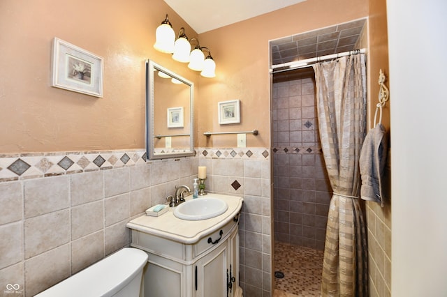 1910 Ivy Dr, Anderson, IN 46011 - bathroom with tile walls, a tile shower, toilet, vanity, and a wainscoted wall