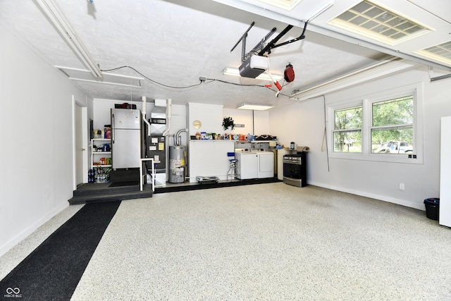 1910 Ivy Dr, Anderson, IN 46011 - garage with freestanding refrigerator, washer and clothes dryer, a garage door opener, water heater, and baseboards