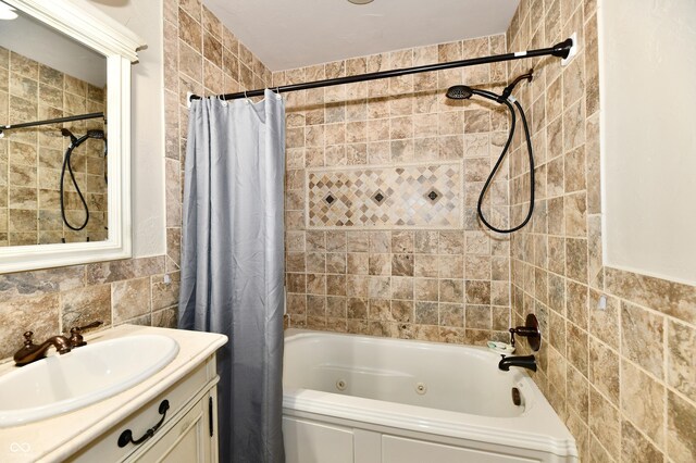 1910 Ivy Dr, Anderson, IN 46011 - bathroom featuring tile walls, a combined bath / shower with jetted tub, and vanity