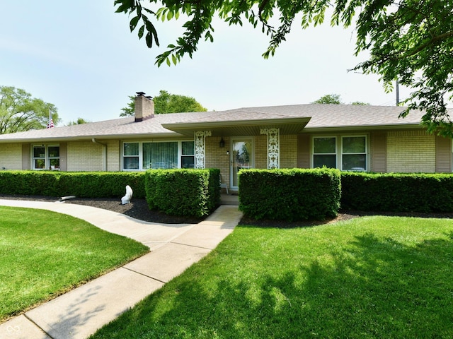 1910 Ivy Dr, Anderson, IN 46011 - ranch-style home featuring brick siding, a front yard, and a chimney
