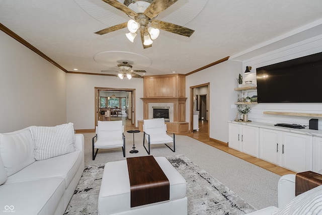 815 Copperfield Ln, Danville, IN 46122 - living area featuring a ceiling fan, crown molding, a large fireplace, and light wood-type flooring