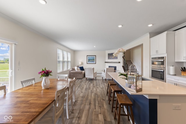 dining space featuring recessed lighting, dark wood-type flooring, and a fireplace