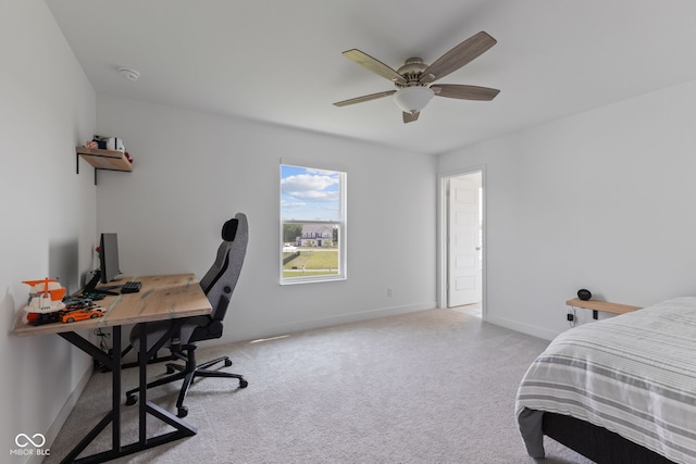 carpeted bedroom featuring an office area, baseboards, and ceiling fan