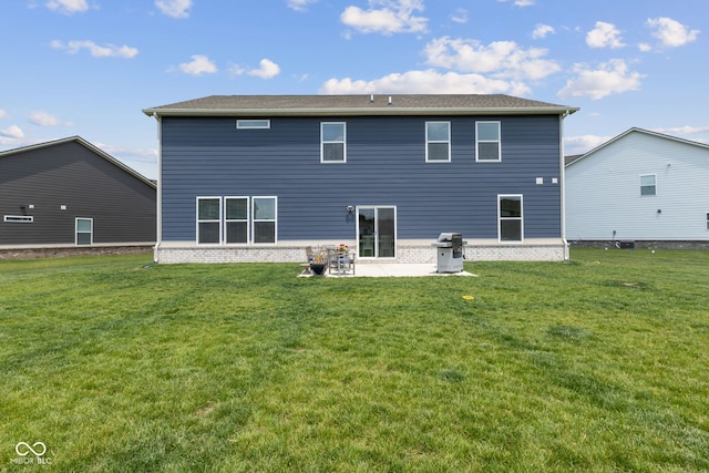 rear view of property featuring a patio, a lawn, and brick siding