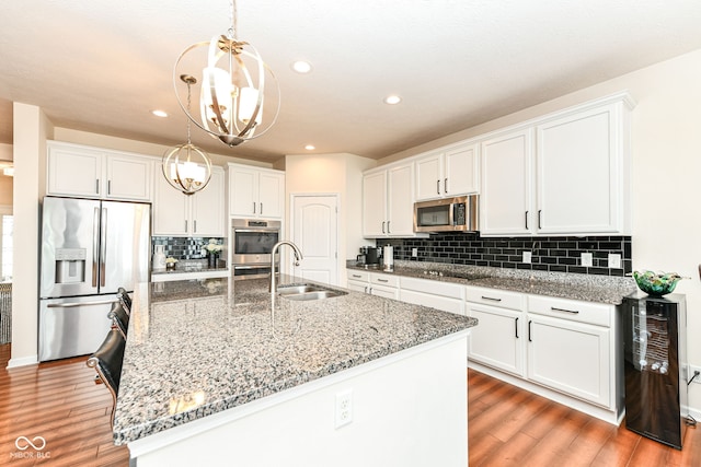 15097 Thoroughbred Dr, Fishers, IN 46040 - kitchen featuring stainless steel appliances, a chandelier, light wood-style floors, white cabinetry, and recessed lighting