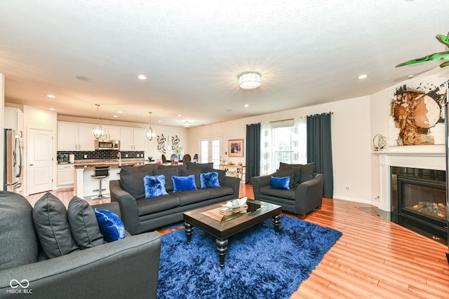 15097 Thoroughbred Dr, Fishers, IN 46040 - living room featuring light wood-style flooring, recessed lighting, and a glass covered fireplace