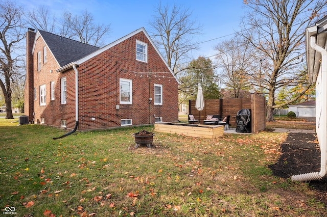 6640 E Washington St, Indianapolis, IN 46219 - view of property exterior featuring a fire pit, brick siding, a yard, roof with shingles, and a chimney