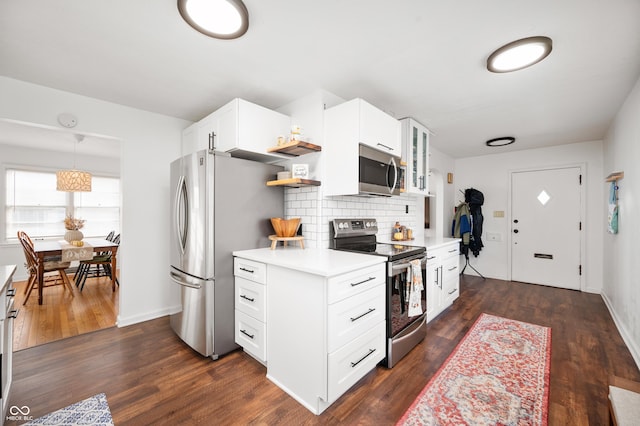 6640 E Washington St, Indianapolis, IN 46219 - kitchen featuring appliances with stainless steel finishes, tasteful backsplash, glass insert cabinets, light countertops, and dark wood finished floors