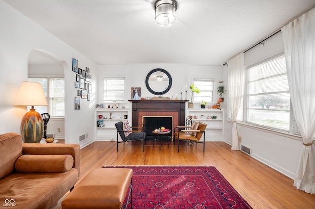 6640 E Washington St, Indianapolis, IN 46219 - living room with wood finished floors, arched walkways, a fireplace, and baseboards