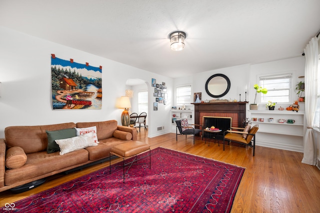 6640 E Washington St, Indianapolis, IN 46219 - living room featuring arched walkways, wood finished floors, and a fireplace