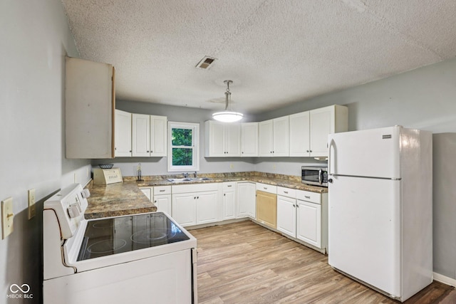 2640 S Silcox Rd, Paragon, IN 46166 - kitchen featuring white appliances, light wood-type flooring, white cabinetry, a textured ceiling, and hanging light fixtures