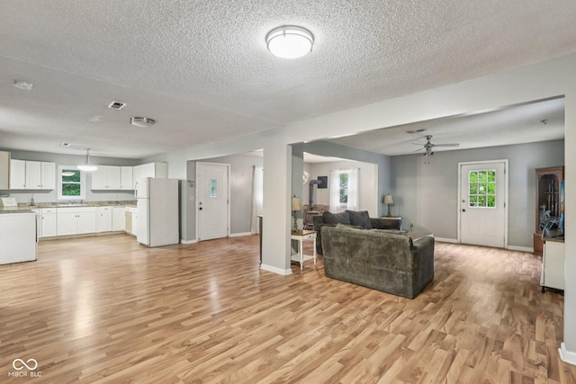 2640 S Silcox Rd, Paragon, IN 46166 - living area with light wood-type flooring, a textured ceiling, a ceiling fan, and plenty of natural light
