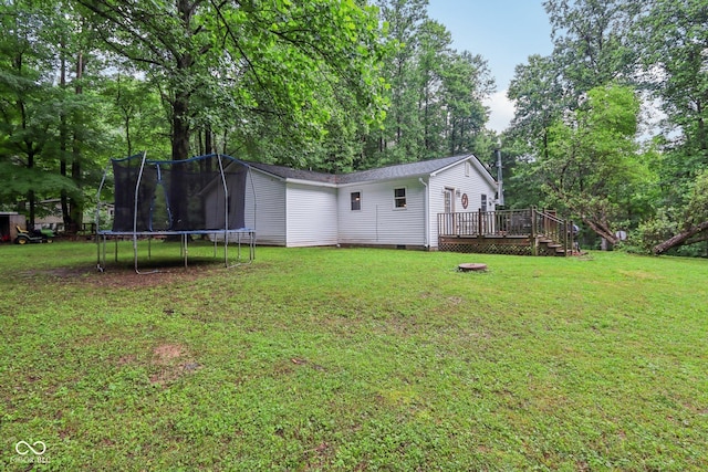 2640 S Silcox Rd, Paragon, IN 46166 - view of grassy yard with a trampoline, a deck, and view of wooded area