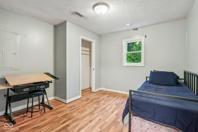 2640 S Silcox Rd, Paragon, IN 46166 - bedroom featuring electric panel, light wood-type flooring, a textured ceiling, and an office area