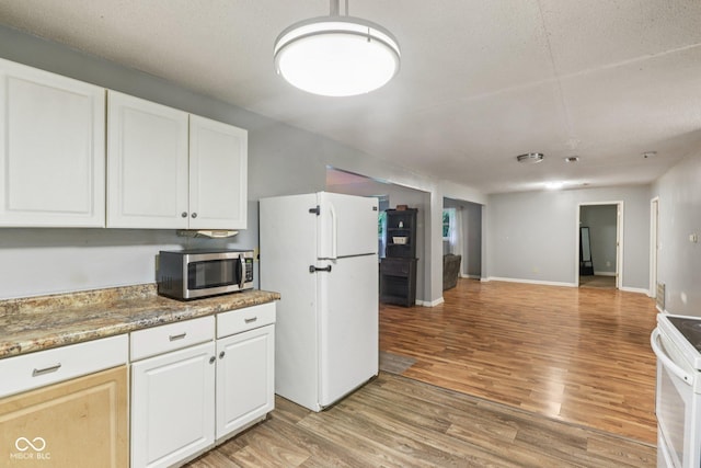 2640 S Silcox Rd, Paragon, IN 46166 - kitchen with white appliances, light wood-style flooring, white cabinetry, and open floor plan