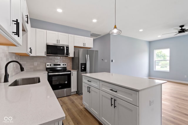 8355 Fieldfare Way, Indianapolis, IN 46237 - kitchen featuring stainless steel appliances, a sink, tasteful backsplash, white cabinetry, and light wood-style floors