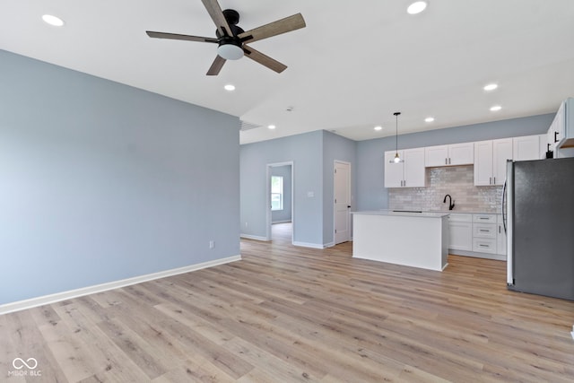 8355 Fieldfare Way, Indianapolis, IN 46237 - kitchen featuring freestanding refrigerator, a center island, light wood-style flooring, recessed lighting, and ceiling fan