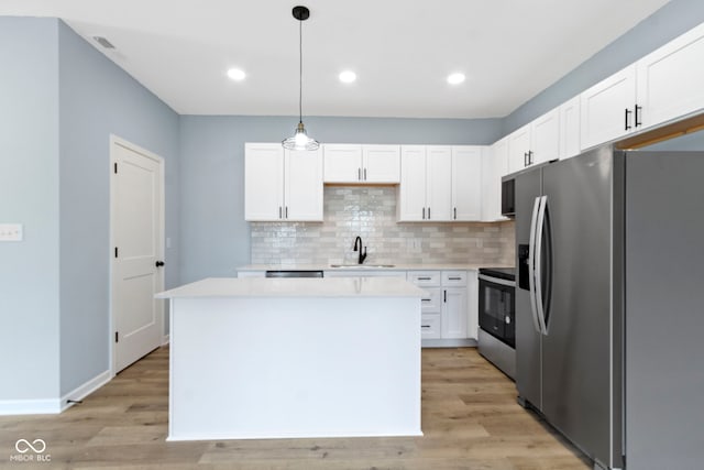 8355 Fieldfare Way, Indianapolis, IN 46237 - kitchen with stainless steel appliances, a sink, a kitchen island, backsplash, and light countertops