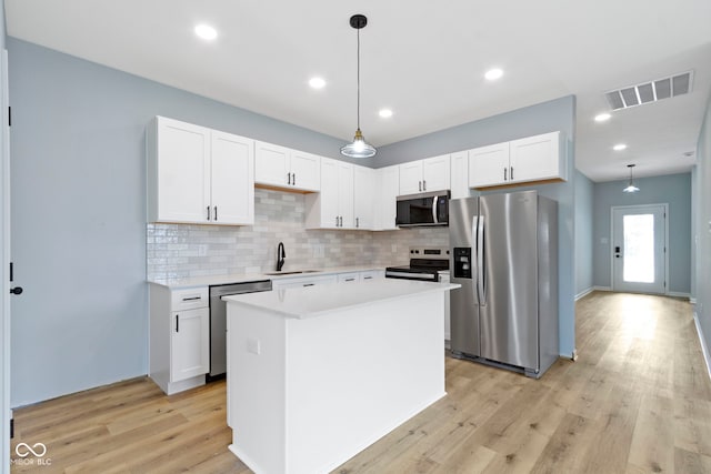 8355 Fieldfare Way, Indianapolis, IN 46237 - kitchen featuring appliances with stainless steel finishes, a sink, tasteful backsplash, light countertops, and light wood-style flooring