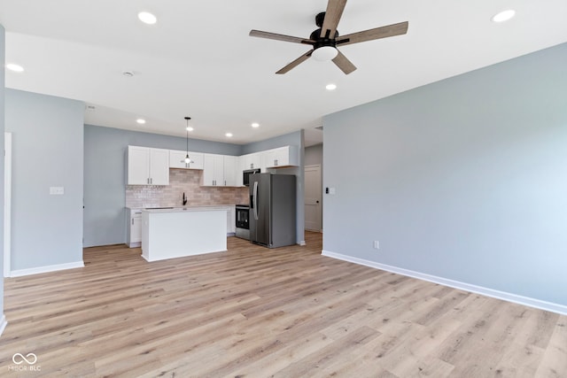 8355 Fieldfare Way, Indianapolis, IN 46237 - kitchen with appliances with stainless steel finishes, open floor plan, ceiling fan, light countertops, and tasteful backsplash