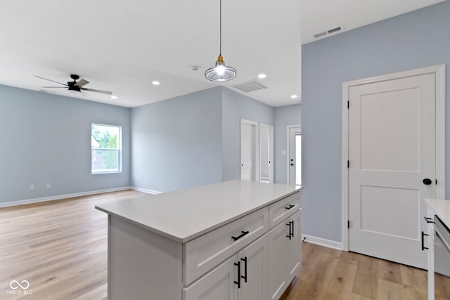 8355 Fieldfare Way, Indianapolis, IN 46237 - kitchen featuring ceiling fan, light wood-style flooring, hanging light fixtures, light countertops, and white cabinetry