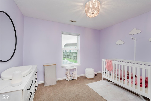 11521 Short Iron Ln, Indianapolis, IN 46235 - bedroom with light carpet, a crib, a chandelier, and baseboards