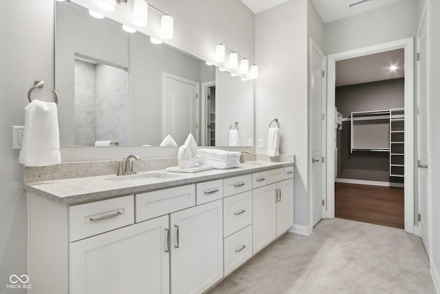 12594 Pasco St, Fishers, IN 46038 - bathroom featuring double vanity, a spacious closet, a tile shower, and baseboards