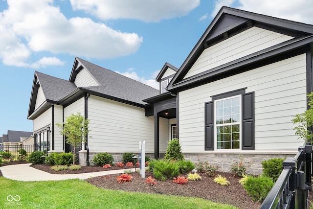 12594 Pasco St, Fishers, IN 46038 - view of side of property with stone siding and a shingled roof