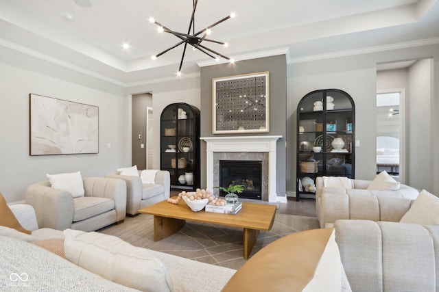 12594 Pasco St, Fishers, IN 46038 - living area featuring a chandelier, a raised ceiling, ornamental molding, and a glass covered fireplace