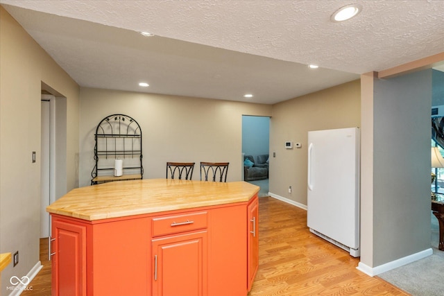 4965 Hawthorne Way, Avon, IN 46123 - kitchen with freestanding refrigerator, butcher block counters, light wood finished floors, recessed lighting, and a center island